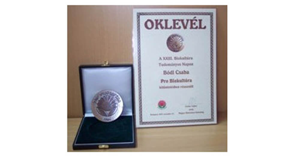 A certificate and a medal are displayed in a case.