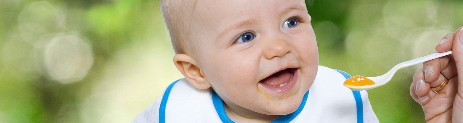 A baby is being fed with a spoon.