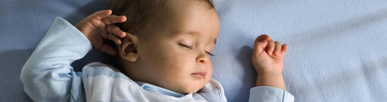 A baby is sleeping on a blue surface.