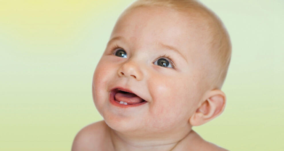A baby with a light complexion and a bald head is looking upwards with a wide open mouth, possibly in a state of wonder or curiosity.