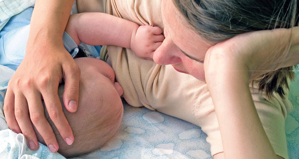 A woman cradles a baby.