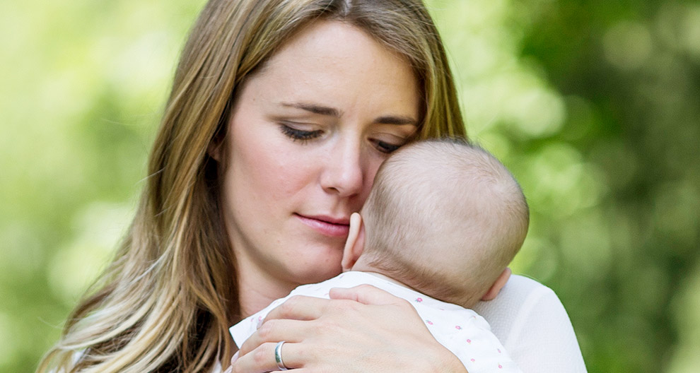 A woman lovingly holds a baby.